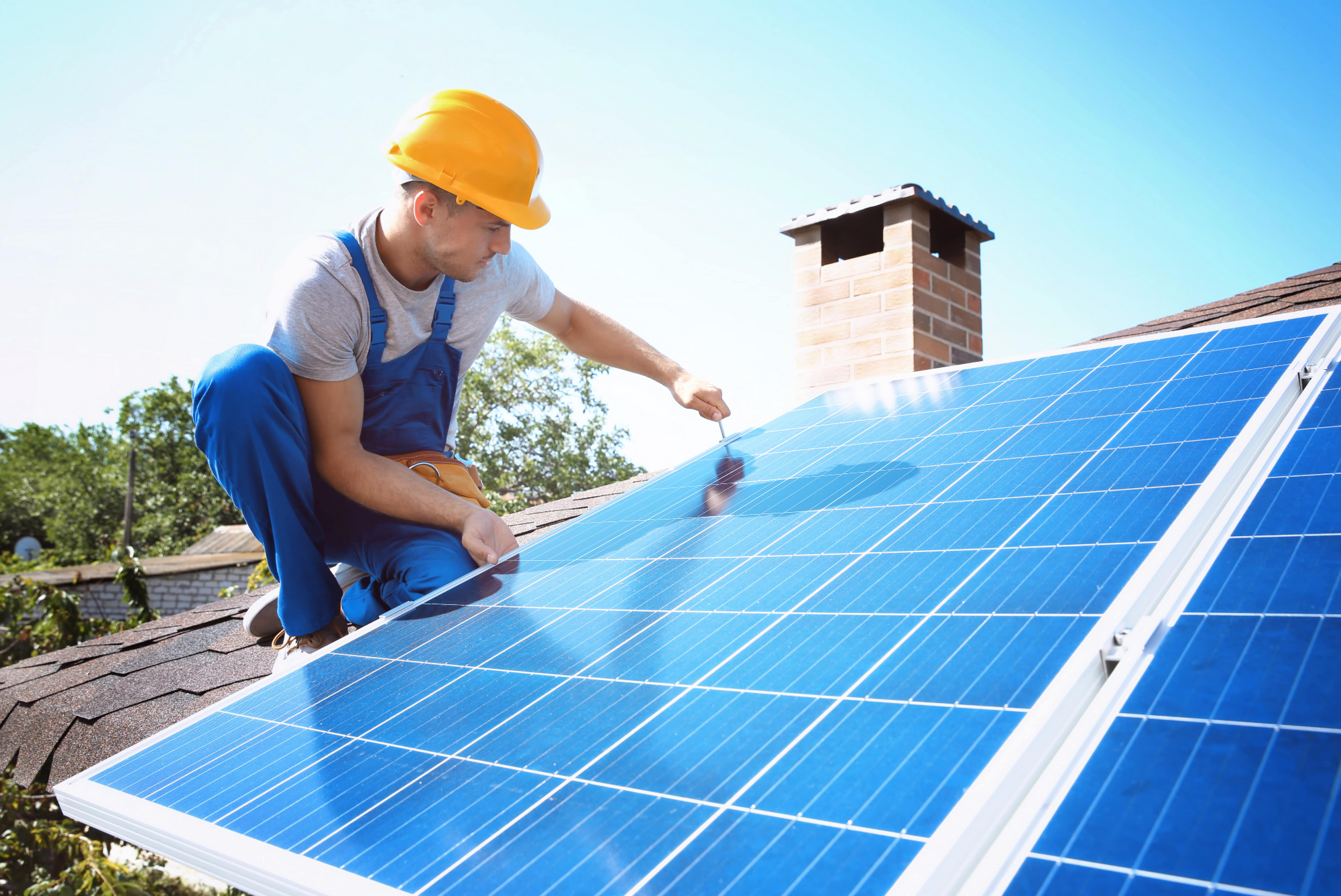 Homme qui pose un panneau solaire sur une toiture