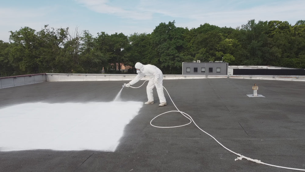 Homme appliquant cool roof Enercool peinture anti chaleur sur toit entreprise